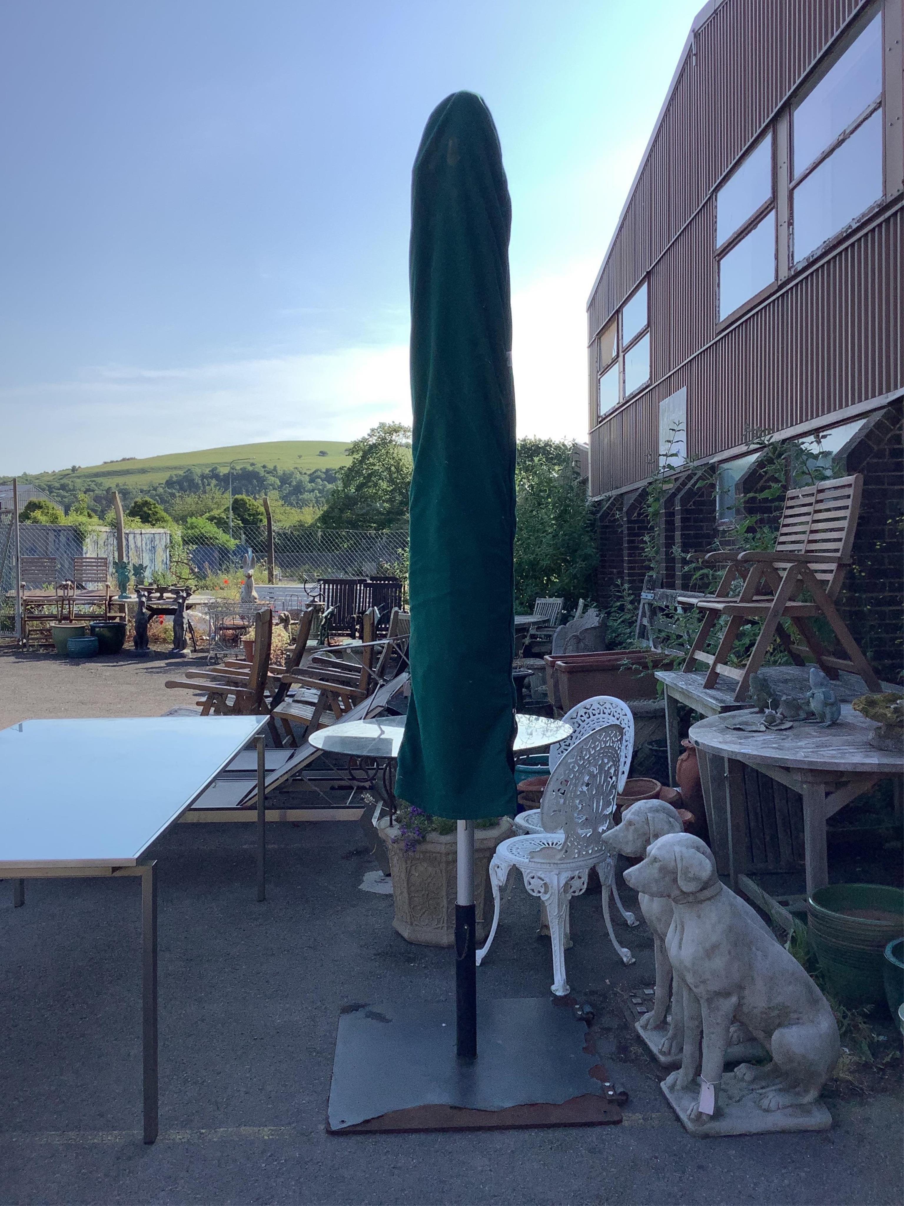 A Barlow Tyrie 10ft diameter white canvas garden parasol with cast iron base and canvas cover. Condition - parasol good, metal base fair